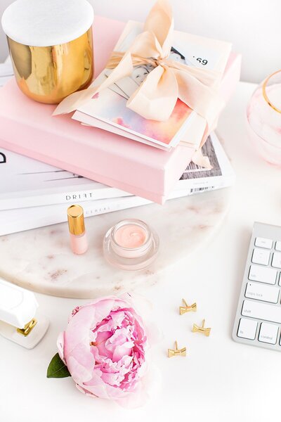 Photo of pink and blush books sitting on a white desk
