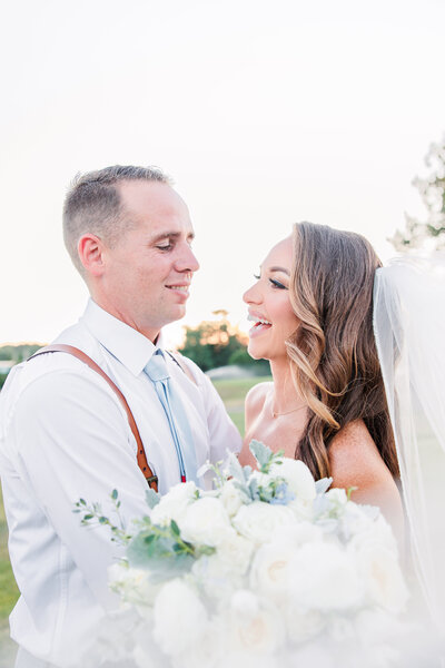 Bride and groom laughing with each other