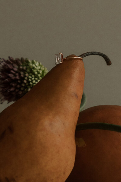 ring resting on pear in fruit bowl