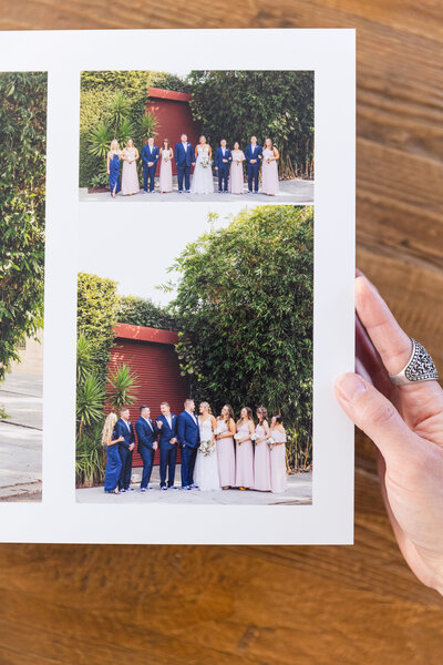 hand holds an open wedding album with photos of wedding party outside Smog Shoppe