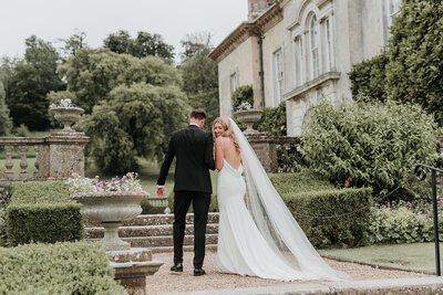Bride and Groom walking closer up stone stairs at their relaxed wedding at Firle Place