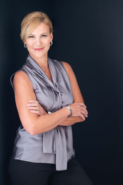 personal branding photos of a woman leaning on a black wall with her arms folded taken by Ottawa Branding Photographer JEMMAN Photography Commercial