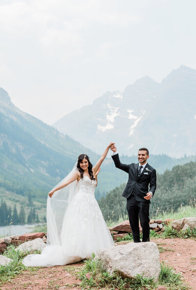 bride and groom holding hands at maroon bells in aspen colorado