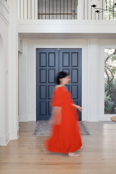 A picture and headshot of Nashville Family Photographer and Systems Educator Dolly DeLong Education wearing a mustard yellow blazer sitting in the nashville pinky house