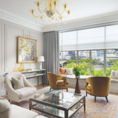 An image of a hotel suite at The Savoy hotel in London, with elegant furniture and a gorgeous view of the city.