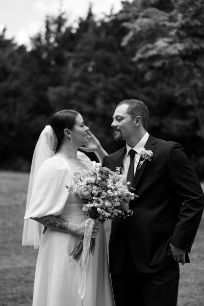 Bride and Groom looking at each other in field
