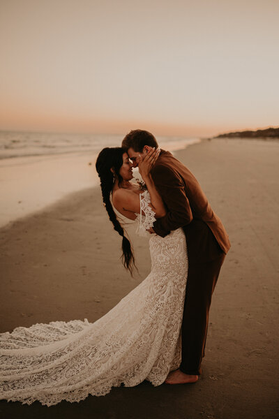 bride and groom posing on the beach
