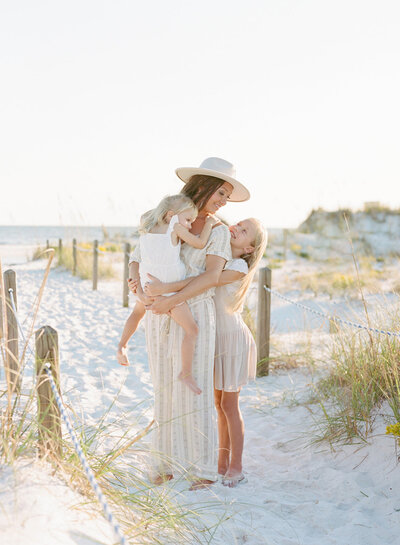 Mother being embraced by her daughters at the beach