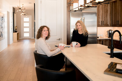 Two women smiling and talking during a home consultation