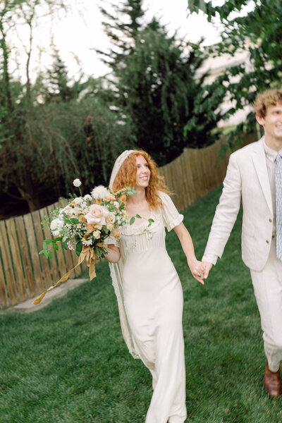 Peyton and Jon laughing together during their backyard wedding in Richmond, VA, captured in candid, documentary-style wedding photography.