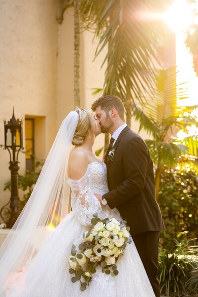 Morgan and Ethan share a romantic kiss in a warm lighting photo at the Powel Crosley Estate in Sarasota, FL.