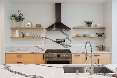 Modern kitchen with black range hood and marble backsplash