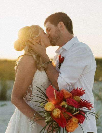 just married couple kissing at the beach 