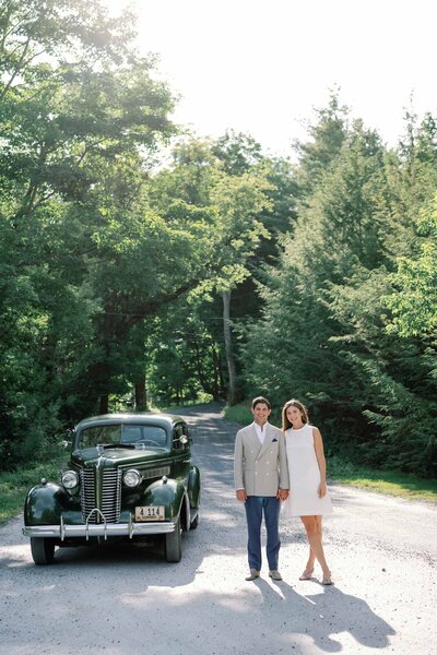 bride and groom stand in front of vintage buick at hildene estate in manchester vermont wedding