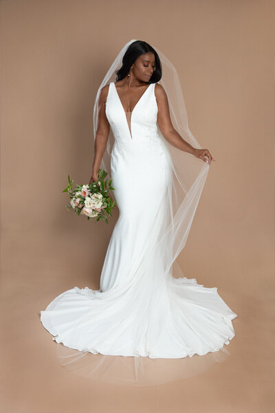 Bride wearing a long chapel length veil and holding a bouquet