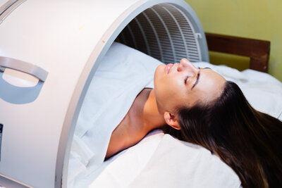 Woman receiving infrared or hyperbaric therapy in a wellness clinic—supporting detox, regeneration, and cellular health