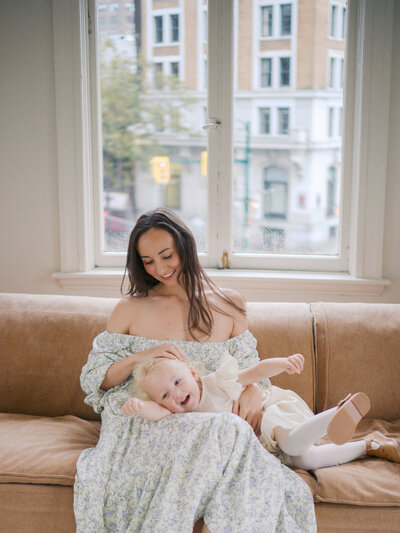Mother and daughter cuddling on a sofa in a studio in Vancouver