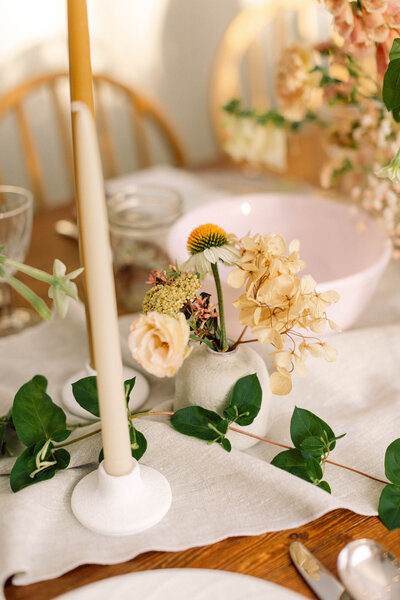 A beautifully designed wedding table with lush floral arrangements and candlelight at Peyton Curry and Jon’s intimate backyard wedding dinner in Richmond, Virginia. Captured by a film-style wedding photographer specializing in candid wedding photography.