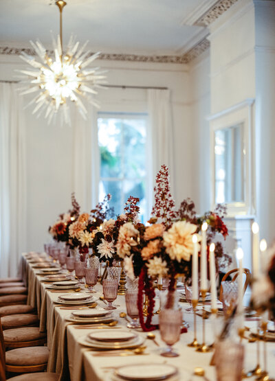 Elegant wedding table setup with mauve florals and gold accents in a historic New Orleans parlor