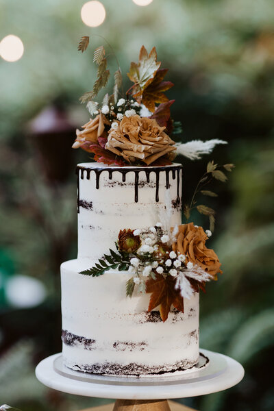 custom two tier cake with chocolate drips and florals