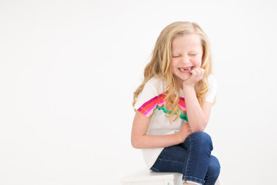 Little girl missing her top two front teeth during photos with Boise Photographer Tiffany Hix in her Boise portrait studio