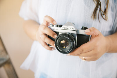 Monique Anne's hands holding a Pentax film camera