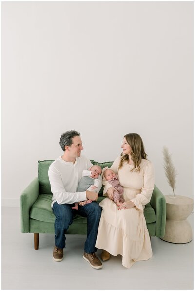 A-family-of-four-sits-on-a-couch-for-christmas-studio-portraits-taken-by-nashville-family-photographer-dolly-delong