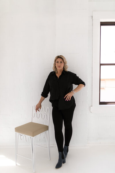 Lady standing next to white chair