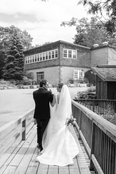 bride groom walking on bridge at Millcroft Inn