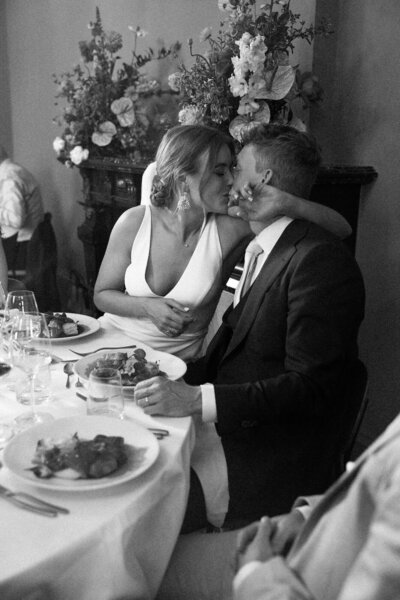 Bruidspaar zoent elkaar tijdens diner door trouwfotograaf Linda Photography 