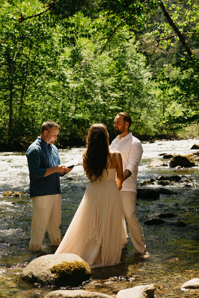 bride and groom standing in river