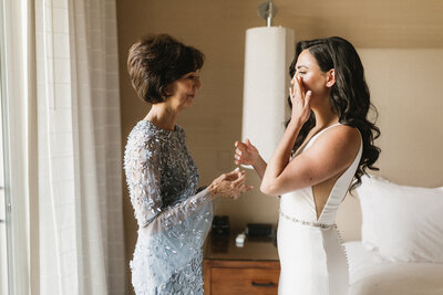 Bride wipes tear after sharing a moment with her mom at Scottsdale Arizona Wedding