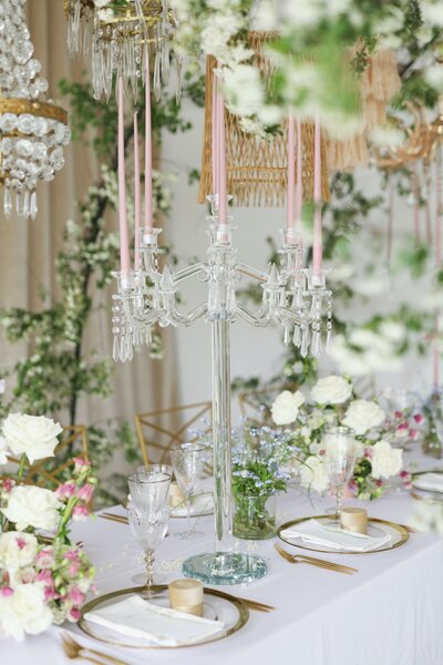 A table with white and pink flowers and candles, creating a beautiful and romantic ambiance.