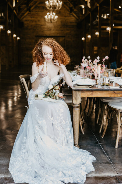 Bride poses at estate table during bridal portraits.