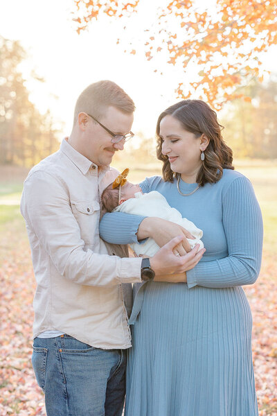 Mom and dad looking at baby lovingly taken by a photographer in Sterling, Virginia