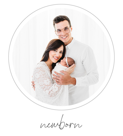 The image shows a couple proudly holding a newborn baby, radiating joy and love. The photograph is captured on a pristine white background, creating a clean and timeless aesthetic. The photographer, Bri Sullivan, skillfully captures the tender moment, showcasing the couple's happiness and their precious new addition.