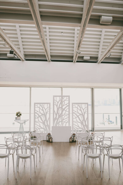 Indoor wedding ceremony setup with chairs and altar.