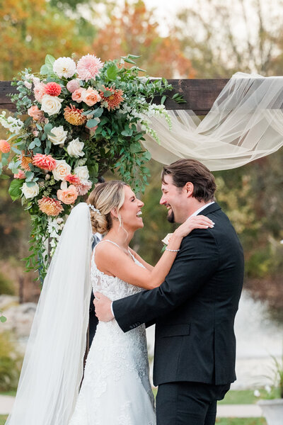 Elegant ceremony space at Manor House with a floral arch featuring white roses and eucalyptus by Leigh Florist
