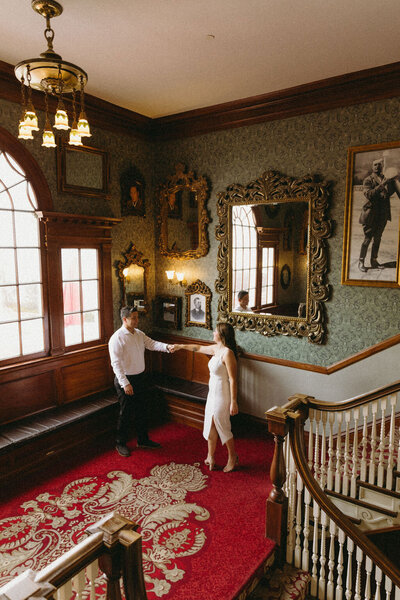 Couple dancing in The Stanley Hotel during their classy, vintage engagement session in Colorado.