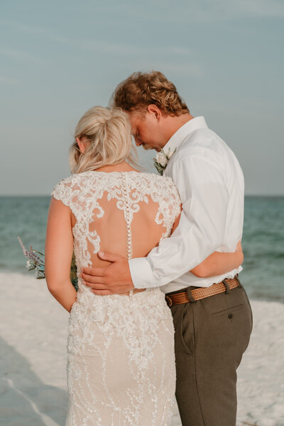 Bride and groom praying before their intimate navarre beach elopement ceremony Elopement-photographer-micro-wedding-destination-photographer-couples-picture