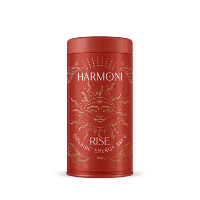 A purple tin labeled "Harmoni Ritual" featuring ornate gold designs and the text "Ceremonial Cacao." The elegant packaging showcases a stylized cacao pod and a ceremonial cup, emphasizing the product's luxurious and spiritual essence.