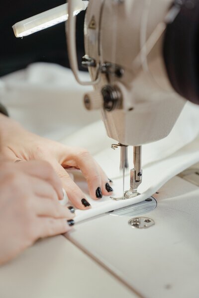 Professional tailor sewing a wedding gown