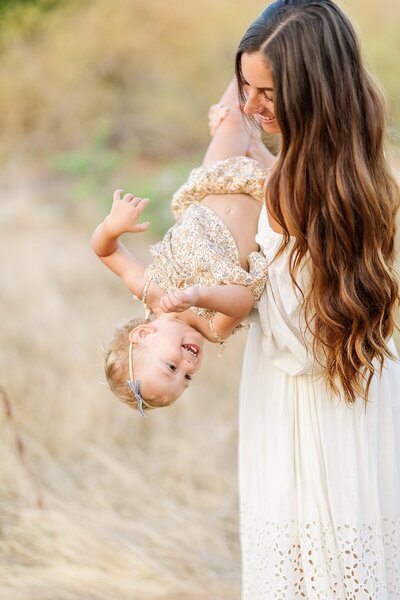 Child kissing mom's baby bump at maternity session at South Lake Park in San Marcos, California.