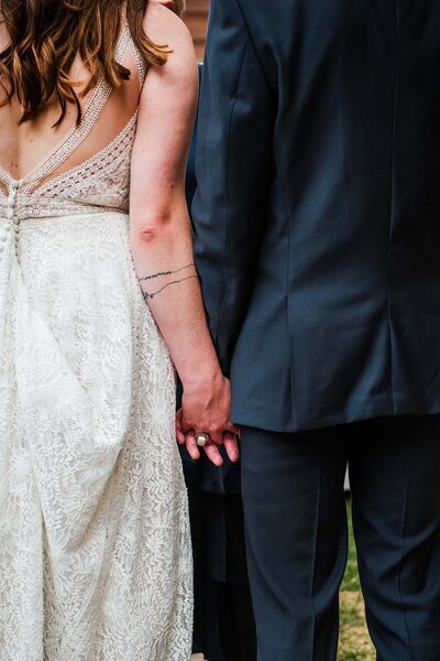 A bride and groom hold hands at their wedding ceremony in Montana.