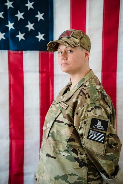 female army veteran standing in front of the American flag