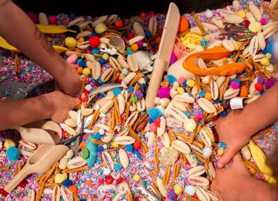 A closeup of toddler hands digging in the sensory bins at the Nest, a preschool in Surf City, NC