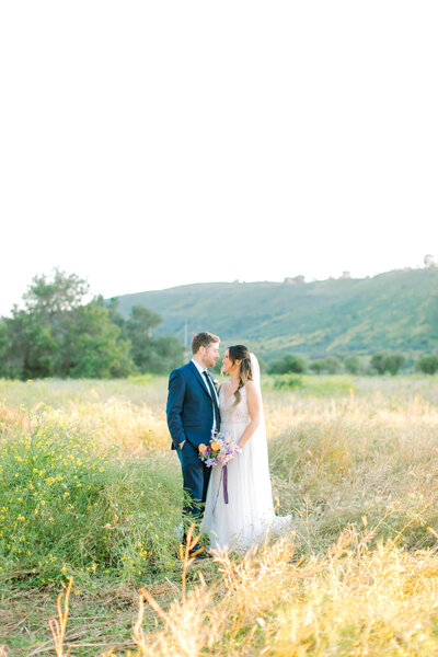 wedding photography of couple in front of field with mountain view in the back in orange county
