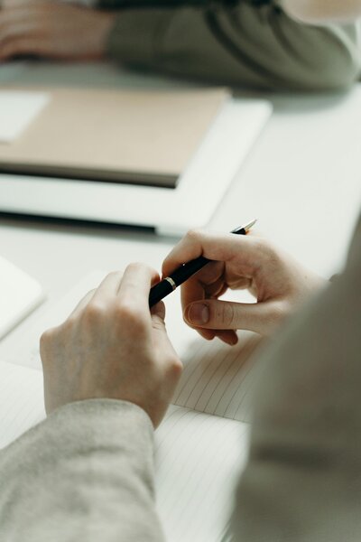 Therapist taking notes with pen during session at Dayspring Counseling