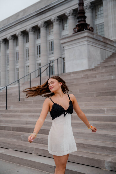 Girl spins on the stairwell in a dress at the state capital.