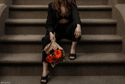 woman holding flowers on staircase